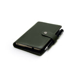 Green full-grain leather A6 notebook and pen set, flat lay, angled view — personalised with debossed initials — CarveOn, made in Ireland