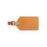 Tan full-grain leather luggage tag, flat lay — personalised travel accessory — CarveOn, made in Ireland