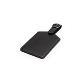 Black full-grain leather luggage tag, flat lay, angled view — personalised travel accessory — CarveOn, made in Ireland