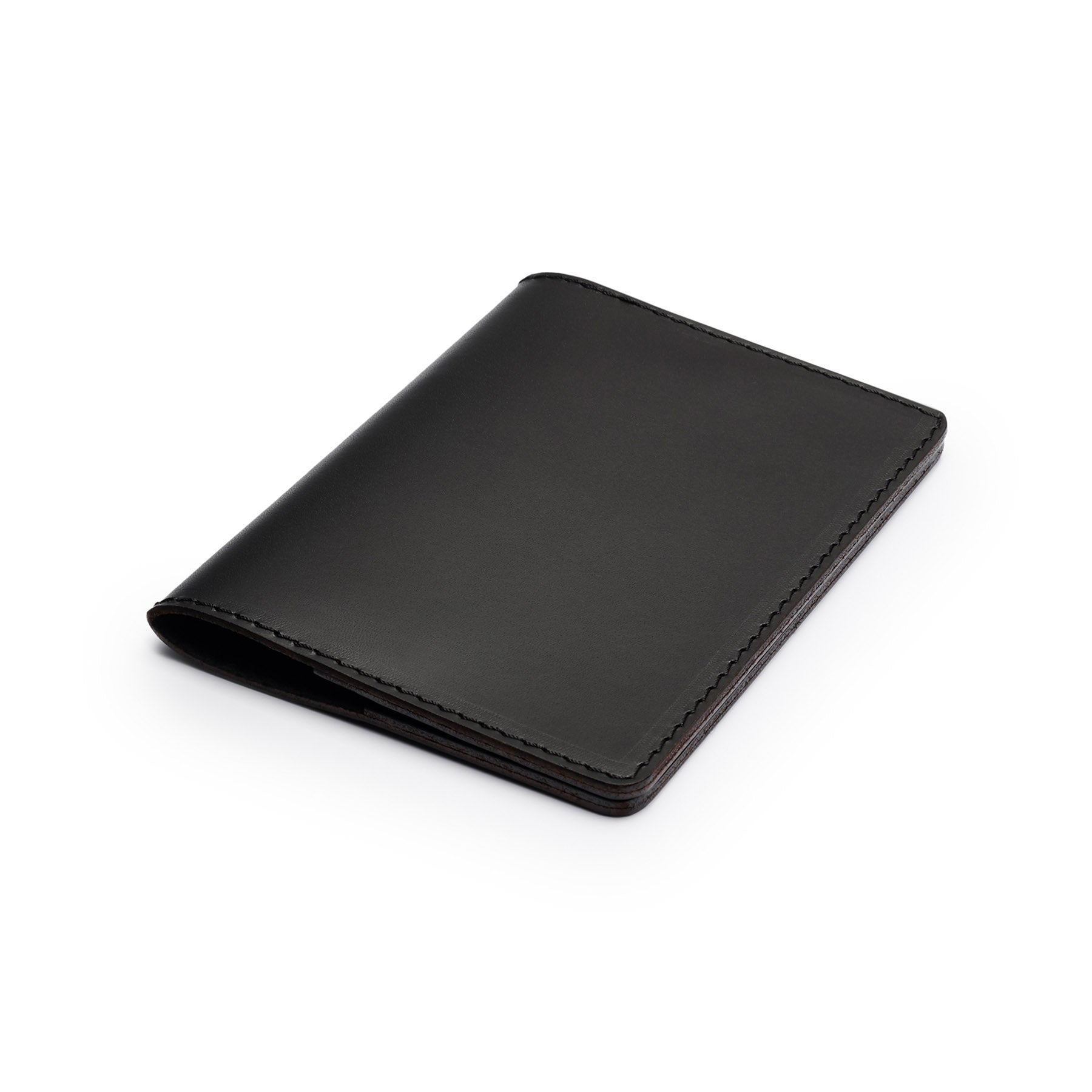 Black full-grain leather passport holder, flat lay, angled view — personalised travel gift — CarveOn, made in Ireland#Color_Black