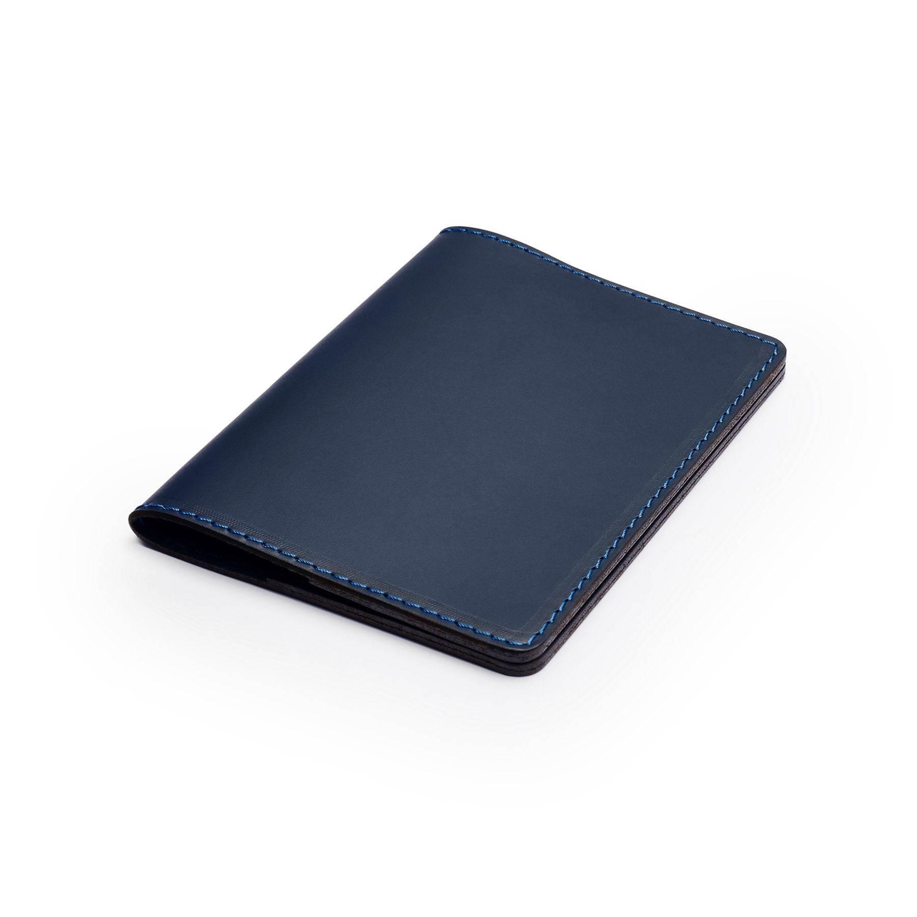 Navy full-grain leather passport holder, flat lay, angled view — personalised travel gift — CarveOn, made in Ireland#Color_Navy